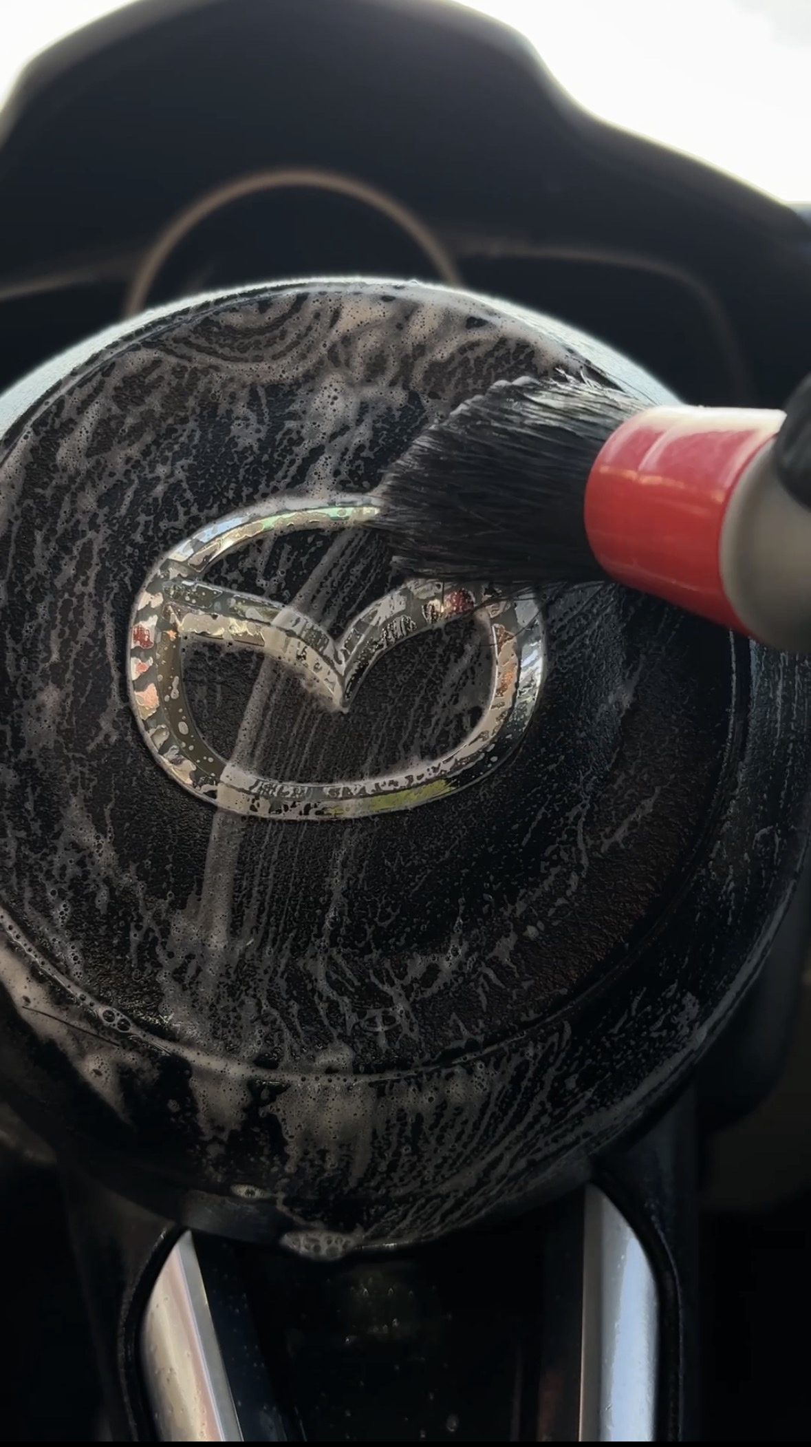 Mazda steering wheel detail cleaning with brush and foam